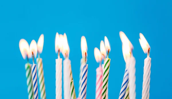 Velas de cumpleaños ardiendo sobre fondo azul — Foto de Stock