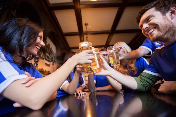 Futbol hayranları, bira bardakları tokuşturup bar veya pub — Stok fotoğraf