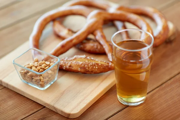 Крупним планом пиво, кренделі та арахіс на столі — стокове фото