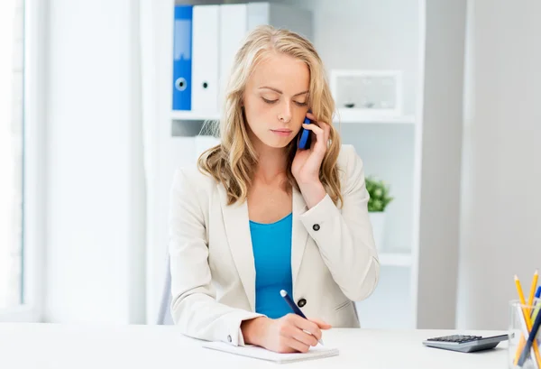 Empresária chamando no smartphone no escritório — Fotografia de Stock