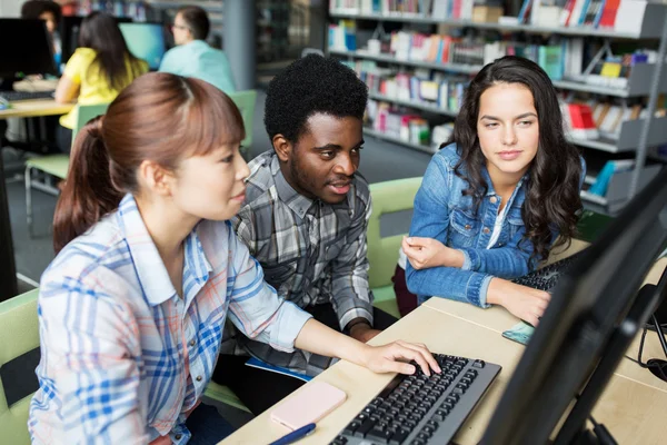 Internationale studenten met computers in de bibliotheek — Stockfoto