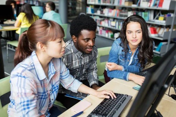 Studenci zagraniczni z komputerami w bibliotece — Zdjęcie stockowe