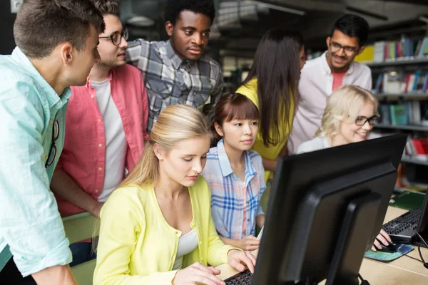 Estudantes internacionais com computadores na biblioteca — Fotografia de Stock