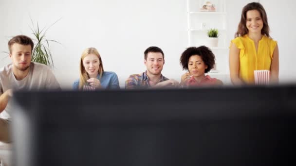 Amigos felizes com pipocas assistindo tv em casa — Vídeo de Stock