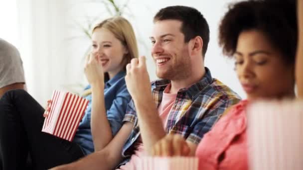 Счастливые друзья с кукурузой, смотрящие телевизор дома — стоковое видео