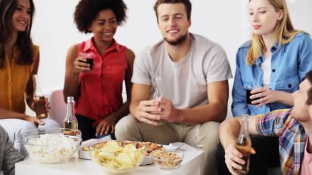 Друзі з напоями і закусками розмовляють вдома — стокове відео