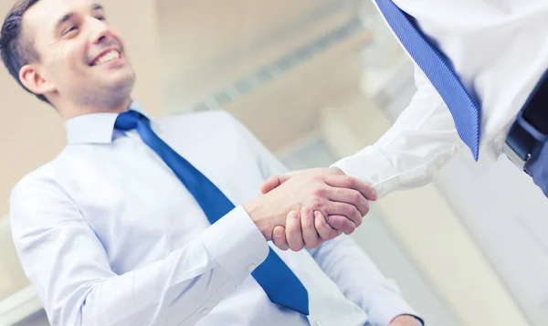 Два бизнесмена пожимают друг другу руки в офисе — стоковое фото