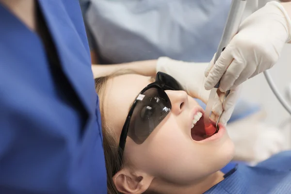 Dentistas mujeres que tratan los dientes de niña paciente —  Fotos de Stock