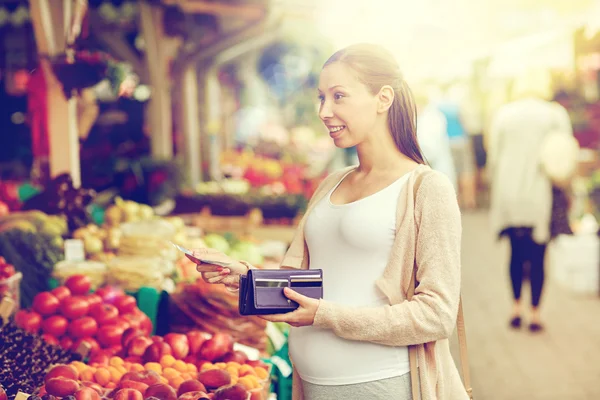 Pregnant woman with wallet buying food at market — Stock Photo, Image