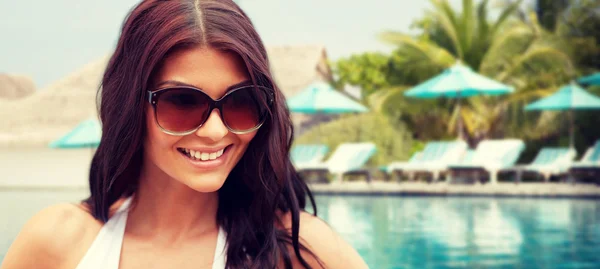 Lachende jonge vrouw met zonnebril op strand — Stockfoto