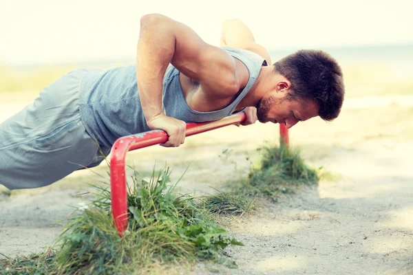 Jongeman die buiten op de horizontale balk traint — Stockfoto