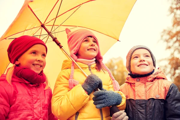 Niños felices con paraguas en el parque de otoño —  Fotos de Stock