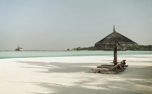 Palapa e lettini per mare sulla spiaggia delle Maldive — Foto Stock