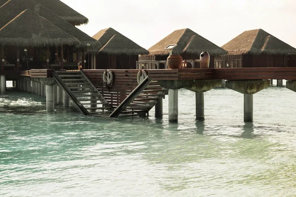 Bungalow huts i havsvatten på exotiska resort beach — Stockfoto