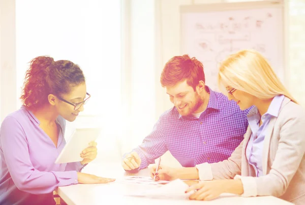 Team sorridente con pc da tavolo e carte funzionanti — Foto Stock