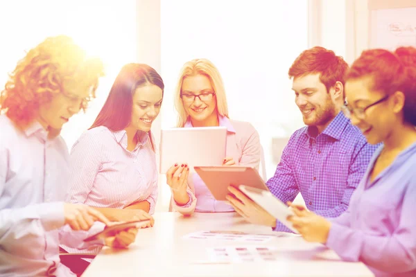 Équipe souriante avec table pc et papiers de travail — Photo