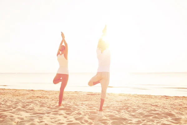 Pareja haciendo ejercicios de yoga al aire libre desde atrás —  Fotos de Stock