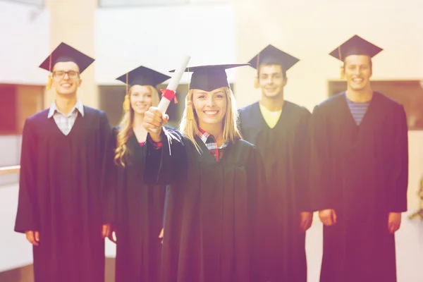 Grup gülümseyen öğrenci mortarboards içinde — Stok fotoğraf