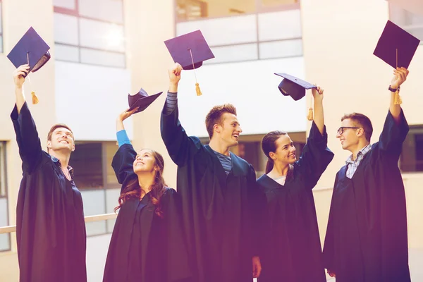 Gruppo di studenti sorridenti in mortai — Foto Stock