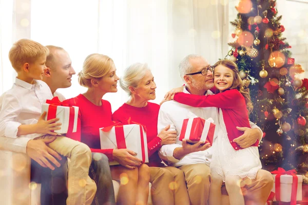 Smiling family with gifts at home — Stock Photo, Image