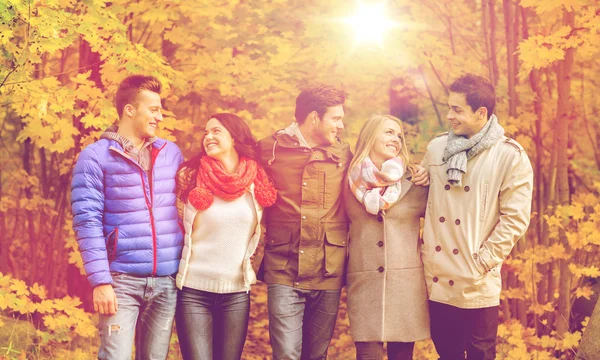 Grupo de hombres y mujeres sonrientes en el parque de otoño — Foto de Stock