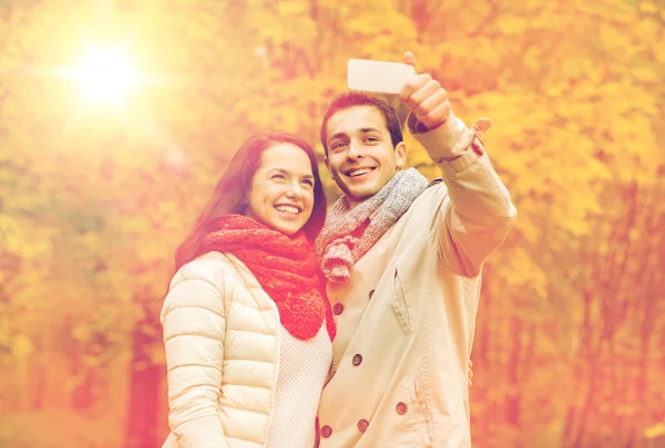 Coppia sorridente che si abbraccia nel parco autunnale — Foto Stock