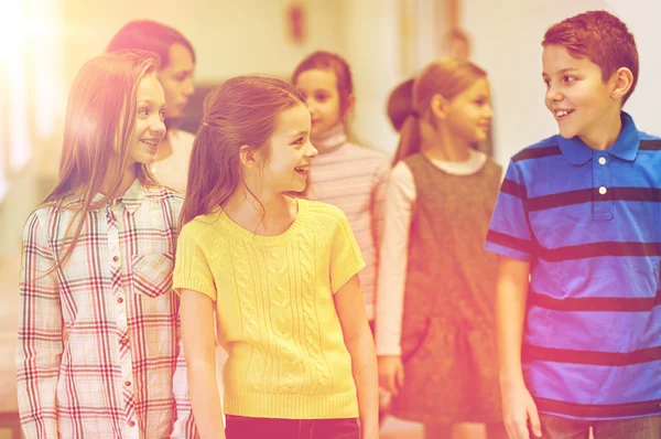 Grupp av leende skola barn gå i korridoren — Stockfoto