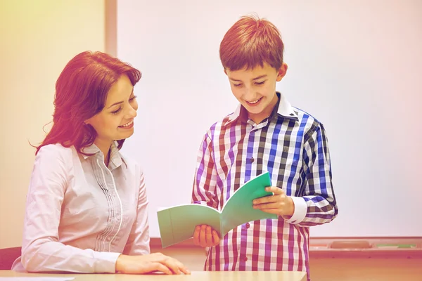 Skolan pojke med anteckningsboken och lärare i klassrummet — Stockfoto