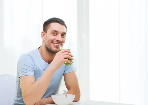 Lykkelig mand spiser morgenmad derhjemme - Stock-foto