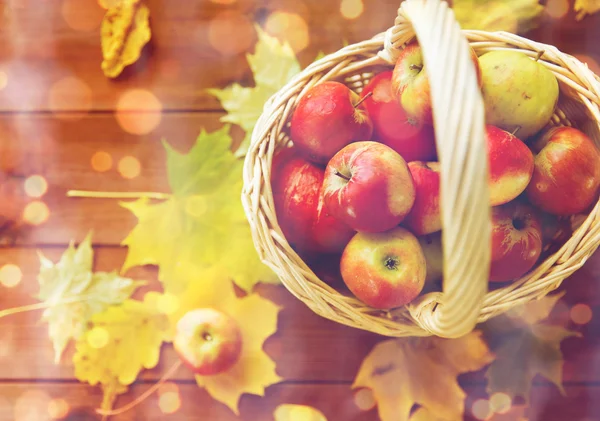 Close up of basket with apples on wooden table — Stock Photo, Image