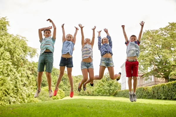 Happy kids jumping and having fun in summer park — Stock Photo, Image