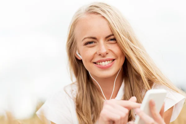 Mulher feliz com smartphone e fones de ouvido — Fotografia de Stock