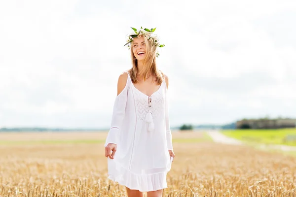 Happy young woman in flower wreath on cereal field — Stock Photo, Image