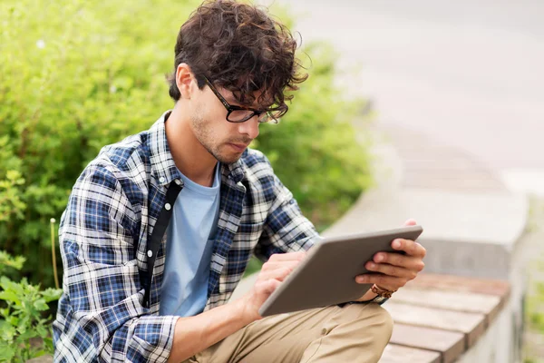 Uomo con tablet pc seduto sulla panchina della città — Foto Stock