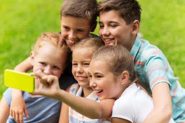 Szczęśliwe dzieci lub przyjaciół, biorąc selfie w lato park — Zdjęcie stockowe