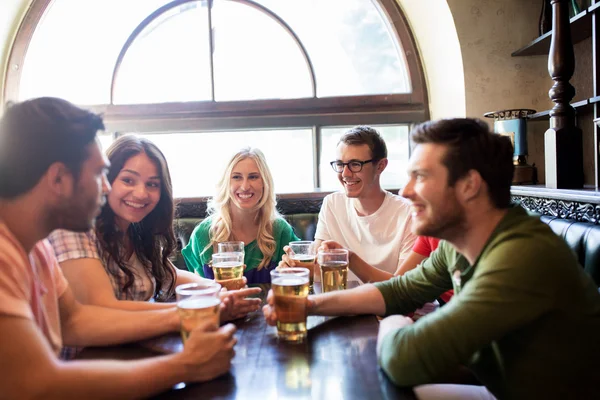 Amigos felizes bebendo cerveja no bar ou pub — Fotografia de Stock