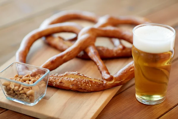 Primer plano de la cerveza, pretzels y cacahuetes en la mesa — Foto de Stock