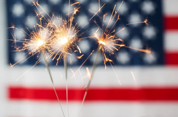 Close up of sparklers burning over american flag — Stock Photo, Image