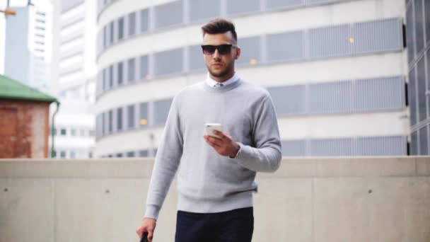 Jeune homme avec des lunettes de soleil et sac de marche en ville — Video