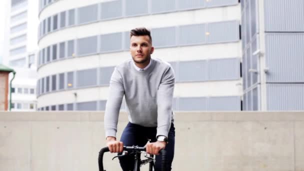 Молодой человек на велосипеде по улице города — стоковое видео