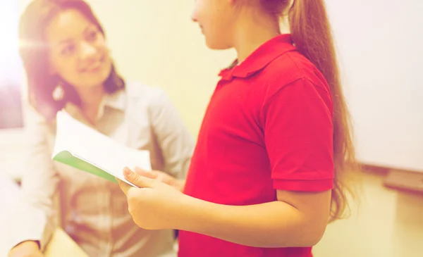 Schulmädchen mit Notizbuch und Lehrer im Klassenzimmer — Stockfoto