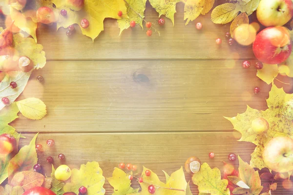 Cornice di foglie autunnali, frutti e bacche su legno — Foto Stock