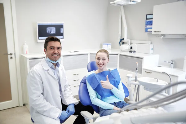 Dentista masculino feliz con paciente mujer en la clínica —  Fotos de Stock