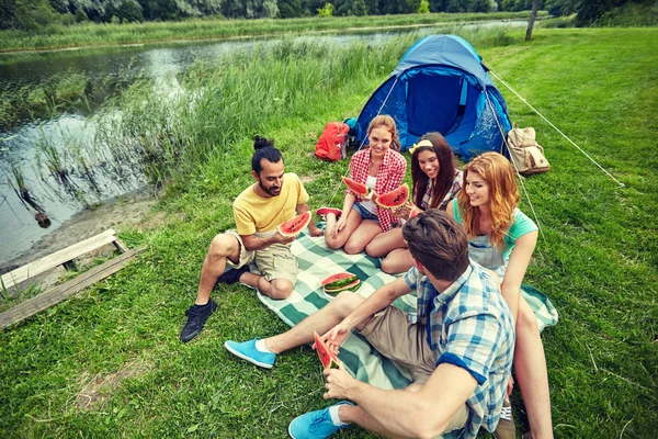 Amigos felices comiendo sandía en el camping —  Fotos de Stock