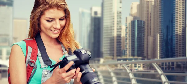 Mujer con mochila y cámara sobre la ciudad de dubai — Foto de Stock