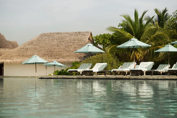 Parasoll och solstolar vid havet på maldives beach — Stockfoto