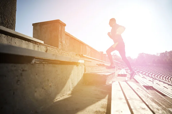 Joven feliz corriendo arriba en el estadio — Foto de Stock