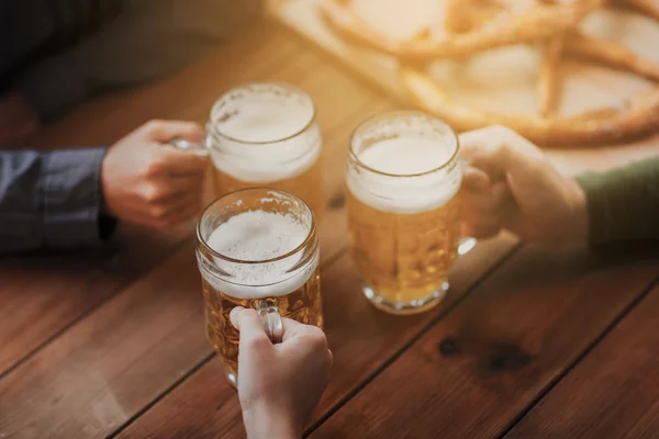Close up of hands with beer mugs at bar or pub — Stock Photo, Image