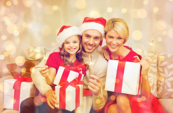 Sorrindo família segurando caixas de presente e brilhos — Fotografia de Stock