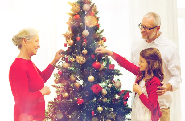 笑みを浮かべて家族飾るクリスマス ツリー自宅 — ストック写真